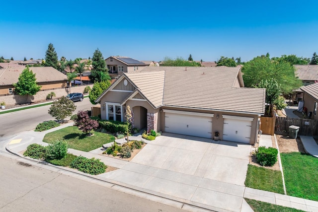 5822 E Booker Ave, Fresno, CA 93727 - view of front of house with stucco siding, a tiled roof, driveway, an attached garage, and a residential view