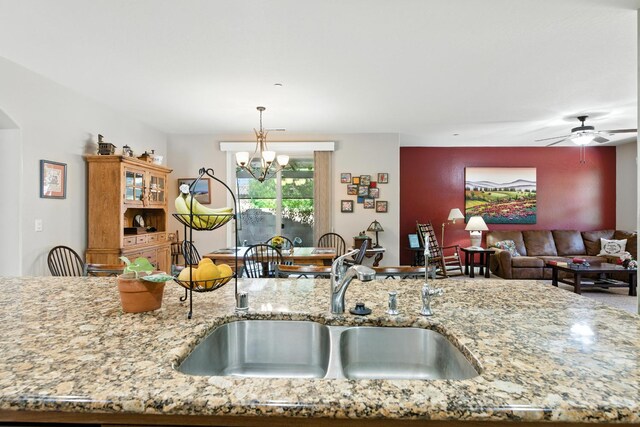 5822 E Booker Ave, Fresno, CA 93727 - kitchen with light stone countertops, decorative light fixtures, open floor plan, ceiling fan, and arched walkways