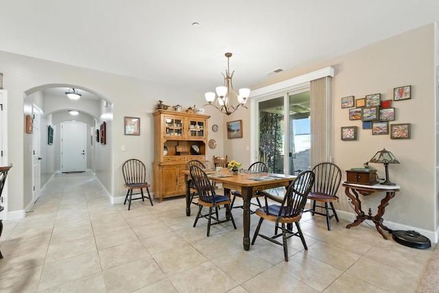 5822 E Booker Ave, Fresno, CA 93727 - dining area featuring arched walkways, a chandelier, and light tile patterned flooring