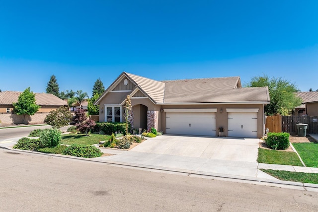 5822 E Booker Ave, Fresno, CA 93727 - view of front of property with stucco siding, a tile roof, an attached garage, and concrete driveway
