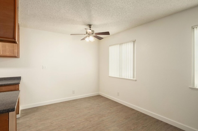 486 W Alamos Ave Unit 3, Clovis, CA 93612 - unfurnished dining area featuring a ceiling fan, light wood-style flooring, and a textured ceiling
