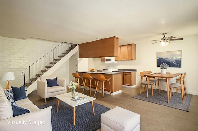 486 W Alamos Ave Unit 3, Clovis, CA 93612 - living room with light wood-style floors, stairs, ceiling fan, and brick wall