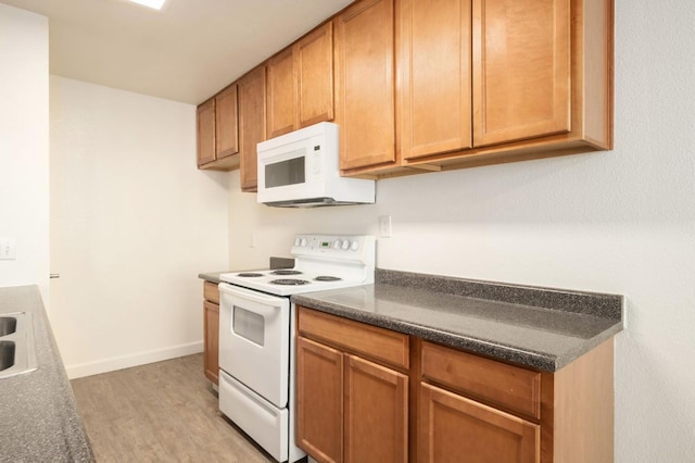 486 W Alamos Ave Unit 3, Clovis, CA 93612 - kitchen featuring white appliances, light wood-style floors, dark countertops, and brown cabinetry