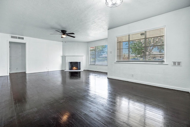 3677 N Thesta St, Fresno, CA 93726 - unfurnished living room with a ceiling fan, dark wood-style flooring, a brick fireplace, and a textured ceiling