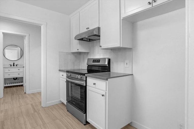 45 E Sussex Way, Fresno, CA 93704 - kitchen featuring stainless steel electric range, under cabinet range hood, tasteful backsplash, white cabinets, and dark countertops