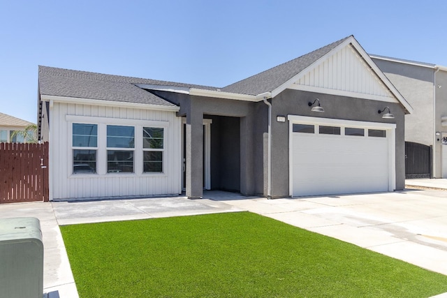 153 N Bliss Ave, Fresno, CA 93727 - view of front of house featuring a garage, concrete driveway, board and batten siding, and a shingled roof