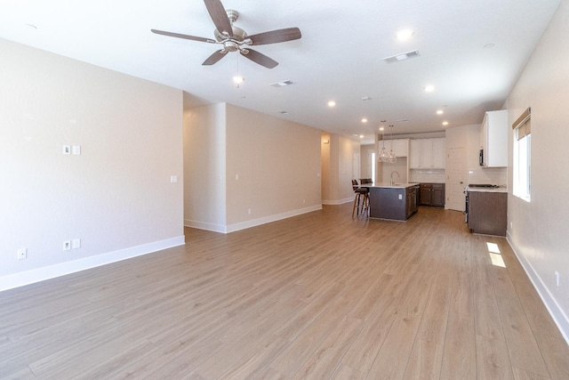 153 N Bliss Ave, Fresno, CA 93727 - unfurnished living room featuring light wood-style floors, ceiling fan, and recessed lighting
