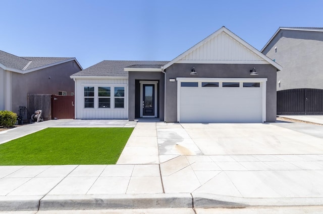 153 N Bliss Ave, Fresno, CA 93727 - view of front of home with an attached garage, concrete driveway, and stucco siding
