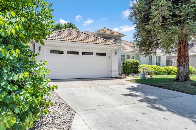 1785 E Portland Ave, Fresno, CA 93720 - mediterranean / spanish home with a tiled roof, a garage, and stucco siding