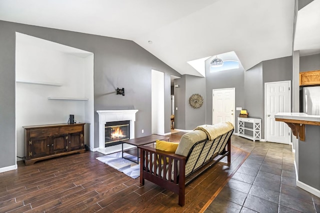 205 N Douglas Ave, Fresno, CA 93727 - living area featuring vaulted ceiling, a glass covered fireplace, and dark wood-type flooring