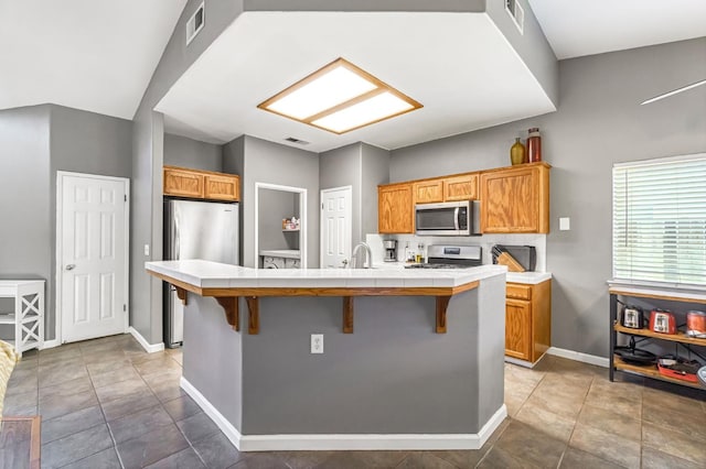 205 N Douglas Ave, Fresno, CA 93727 - kitchen featuring stainless steel appliances, tile countertops, a kitchen bar, and a kitchen island with sink