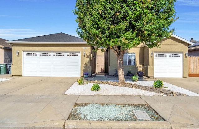 205 N Douglas Ave, Fresno, CA 93727 - view of front facade featuring concrete driveway, an attached garage, and stucco siding