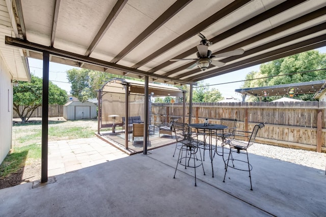 3054 E Brown Ave, Fresno, CA 93703 - fenced backyard with outdoor dining area, a storage unit, a patio area, and a ceiling fan