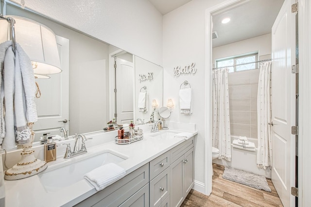 1363 E Via Prato Dr, Fresno, CA 93730 - full bathroom with wood finished floors, double vanity, and shower / bath combo