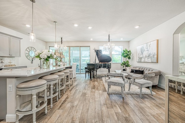 1363 E Via Prato Dr, Fresno, CA 93730 - living area with light wood-type flooring, a chandelier, recessed lighting, and arched walkways