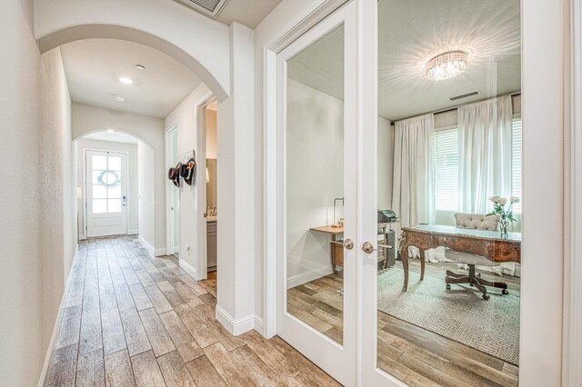 1363 E Via Prato Dr, Fresno, CA 93730 - corridor with arched walkways, light wood-style floors, and french doors