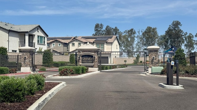 1363 E Via Prato Dr, Fresno, CA 93730 - view of asphalt road with a gate, curbs, a gated entry, and a residential view