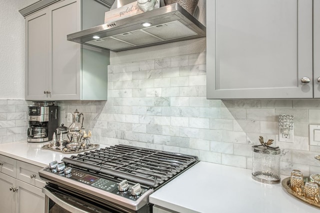 1363 E Via Prato Dr, Fresno, CA 93730 - kitchen with wall chimney range hood, stainless steel range with gas stovetop, light countertops, and decorative backsplash