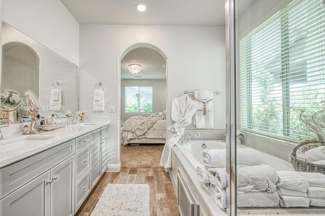 1363 E Via Prato Dr, Fresno, CA 93730 - ensuite bathroom featuring double vanity, a bath, and wood finished floors
