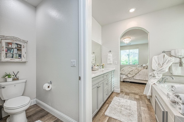 1363 E Via Prato Dr, Fresno, CA 93730 - ensuite bathroom featuring wood finished floors, vanity, a bath, and recessed lighting