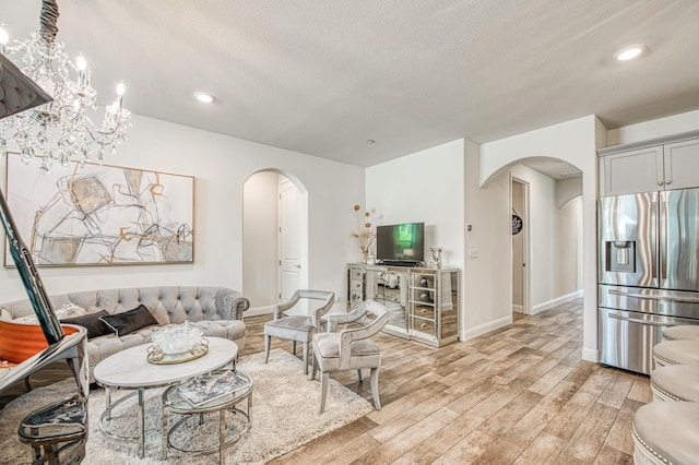 1363 E Via Prato Dr, Fresno, CA 93730 - living area featuring arched walkways, light wood finished floors, a textured ceiling, and recessed lighting