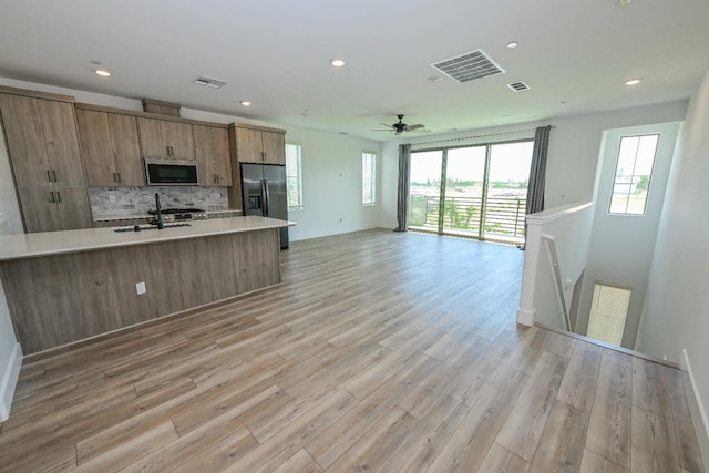 510 W Mahogany Ln, Clovis, CA 93611 - kitchen with stainless steel appliances, light countertops, backsplash, light wood finished floors, and recessed lighting