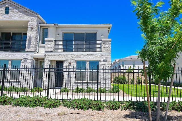 510 W Mahogany Ln, Clovis, CA 93611 - view of front facade with a balcony, stone siding, and stucco siding
