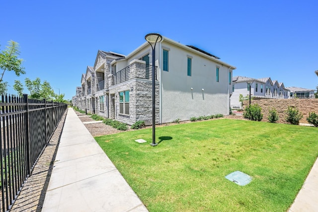 510 W Mahogany Ln, Clovis, CA 93611 - view of side of home featuring stucco siding, a balcony, and stone siding
