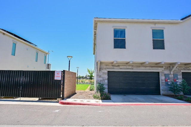 510 W Mahogany Ln, Clovis, CA 93611 - view of front of property featuring stone siding, stucco siding, a garage, and concrete driveway