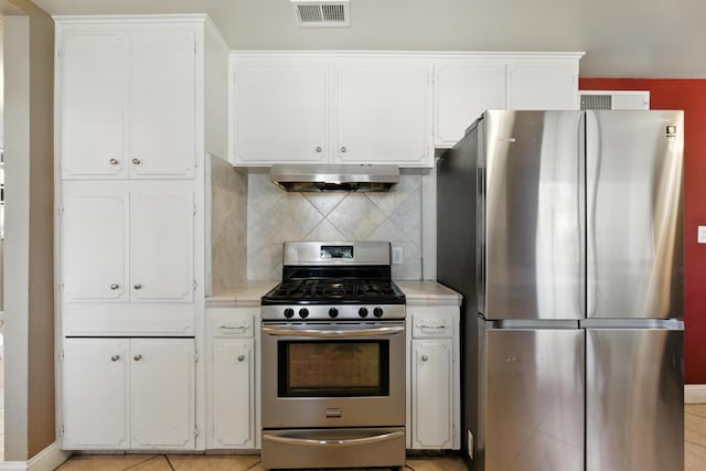 6052 N Spalding Ave, Fresno, CA 93710 - kitchen featuring appliances with stainless steel finishes, white cabinets, under cabinet range hood, and decorative backsplash