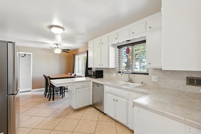 6052 N Spalding Ave, Fresno, CA 93710 - kitchen featuring stainless steel appliances, white cabinets, light tile patterned floors, and backsplash