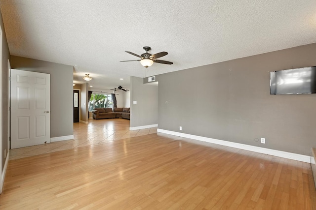 6052 N Spalding Ave, Fresno, CA 93710 - unfurnished living room featuring a ceiling fan, light wood-style floors, and a textured ceiling