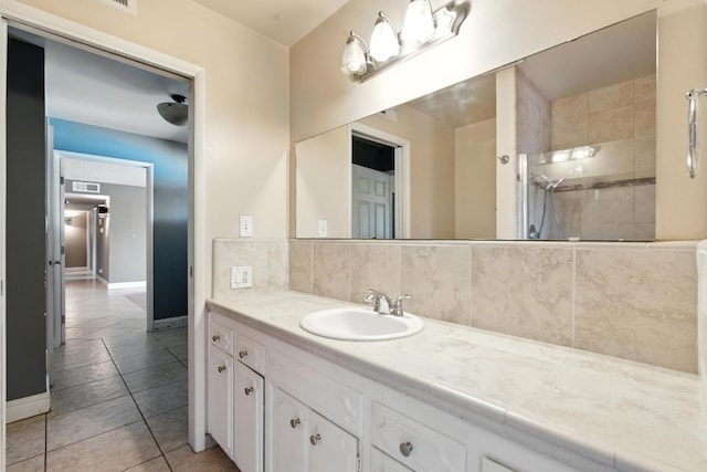 6052 N Spalding Ave, Fresno, CA 93710 - bathroom featuring a tile shower, vanity, tile patterned floors, and decorative backsplash