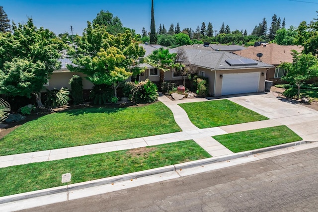 6052 N Spalding Ave, Fresno, CA 93710 - view of front of home with stucco siding, a front yard, solar panels, and concrete driveway