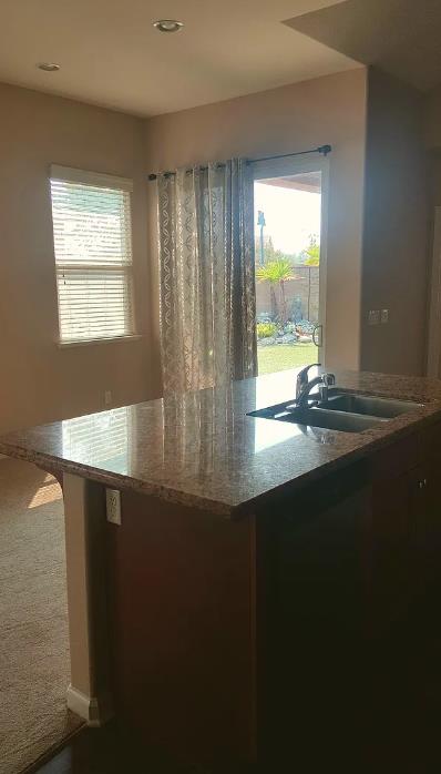 1982 N Todd Hedrick, Clovis, CA 93619 - kitchen featuring healthy amount of natural light, dark carpet, light stone counters, and recessed lighting