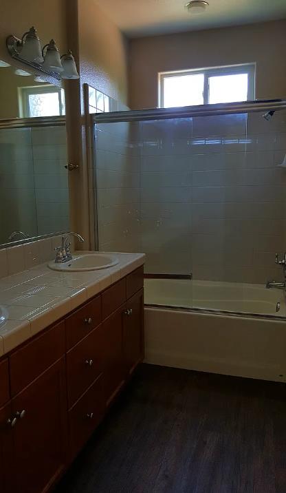 1982 N Todd Hedrick, Clovis, CA 93619 - bathroom featuring  shower combination, wood finished floors, and double vanity