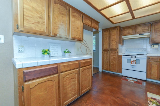 1325 Griffith Ave, Clovis, CA 93612 - kitchen with white electric stove, under cabinet range hood, decorative backsplash, finished concrete floors, and tile counters