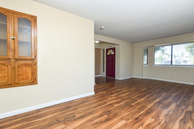 1325 Griffith Ave, Clovis, CA 93612 - spare room featuring dark wood-type flooring and a textured ceiling
