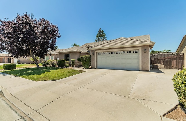 5783 N State St, Fresno, CA 93722 - view of front of home featuring stucco siding, a garage, a front lawn, and a tile roof