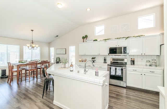 5783 N State St, Fresno, CA 93722 - kitchen featuring stainless steel appliances, tile counters, tasteful backsplash, and high vaulted ceiling