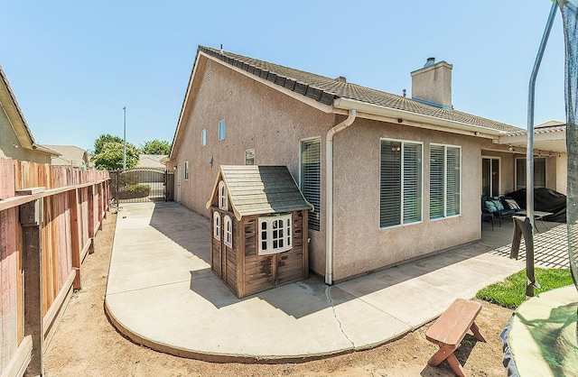 5783 N State St, Fresno, CA 93722 - rear view of house featuring a chimney, a patio area, stucco siding, and a fenced backyard