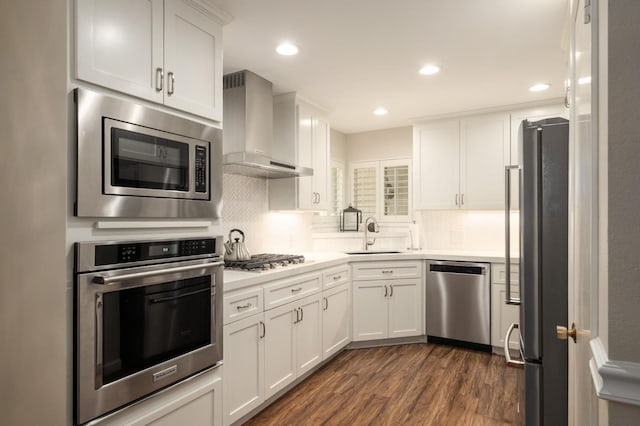3218 E Ellery Ave, Fresno, CA 93710 - kitchen with appliances with stainless steel finishes, wall chimney exhaust hood, dark wood-type flooring, light countertops, and white cabinets