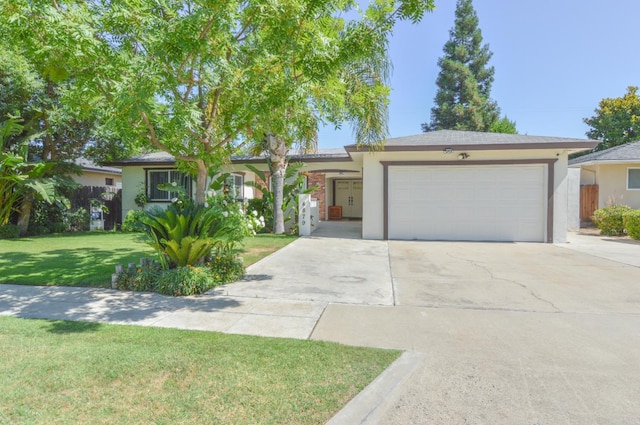 4879 E San Gabriel Ave, Fresno, CA 93726 - ranch-style home featuring a garage, driveway, and stucco siding