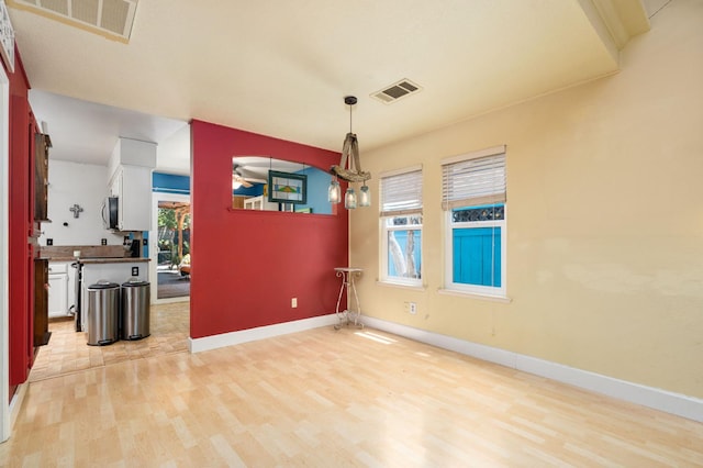 9938 N Canyon Creek Ln, Fresno, CA 93730 - unfurnished dining area featuring light wood-style flooring and baseboards