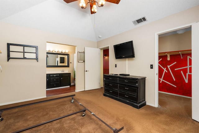 9938 N Canyon Creek Ln, Fresno, CA 93730 - carpeted bedroom with vaulted ceiling, a walk in closet, connected bathroom, a ceiling fan, and a closet