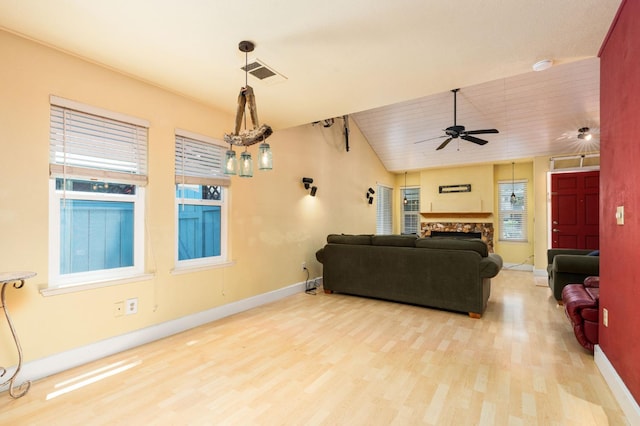 9938 N Canyon Creek Ln, Fresno, CA 93730 - living area featuring ceiling fan, wood finished floors, a fireplace, and plenty of natural light