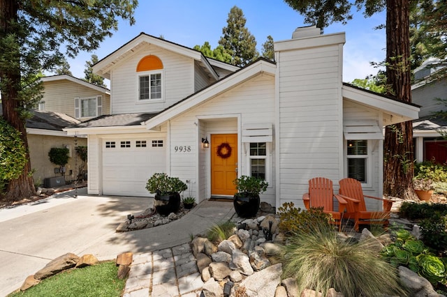 9938 N Canyon Creek Ln, Fresno, CA 93730 - view of front of house with a chimney, an attached garage, and concrete driveway