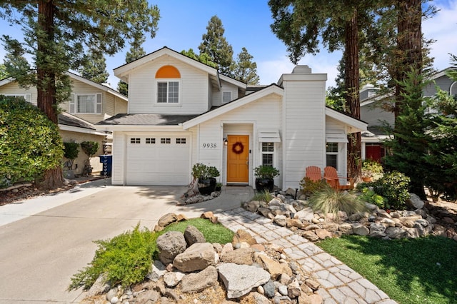 9938 N Canyon Creek Ln, Fresno, CA 93730 - view of front facade featuring a garage, driveway, and a chimney