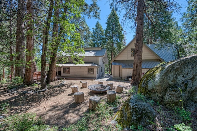 41798 Saddleback Rd, Shaver Lake, CA 93664 - rear view of house with a fire pit, a metal roof, and an outdoor structure
