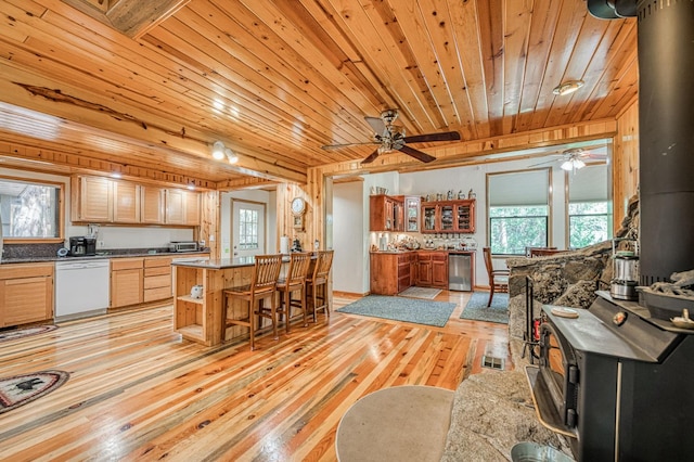 41798 Saddleback Rd, Shaver Lake, CA 93664 - kitchen featuring a wood stove, white dishwasher, wood ceiling, light wood-type flooring, and plenty of natural light